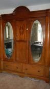A large oval mirrored combination wardrobe