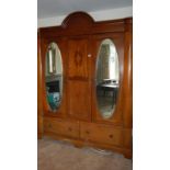 A large oval mirrored combination wardrobe