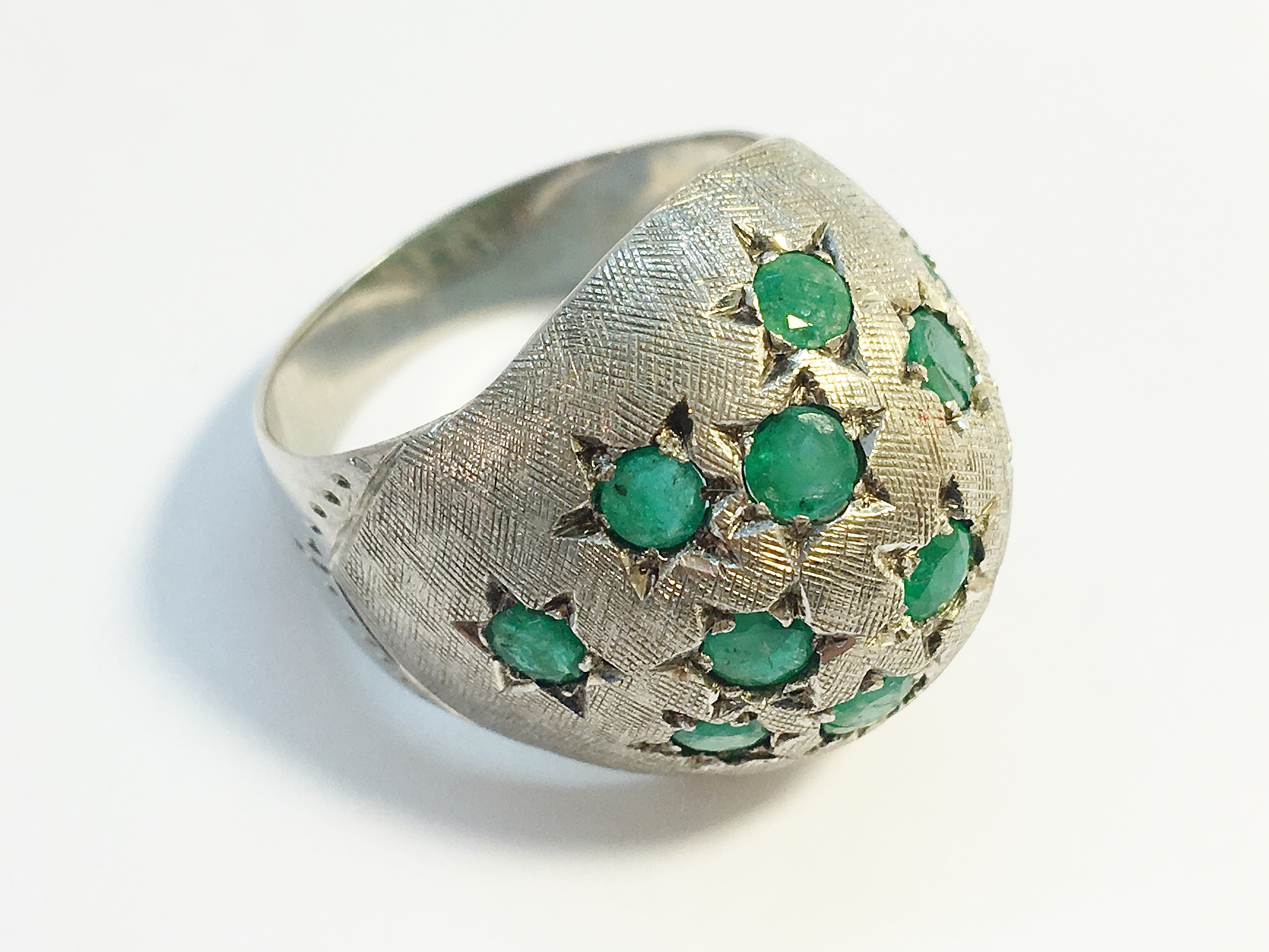 A 1970s emerald bombe ring in 18ct white gold. Set with 15 emeralds in star settings, ETCW 1.12 ct.