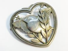 A Georg Jensen silver brooch fashioned as a dove and olive branch within a heart. No 239.