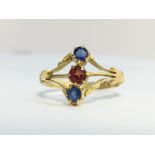 An Antique Sapphire and Garnet Three Stone Ring in ornate 18ct yellow gold shank.