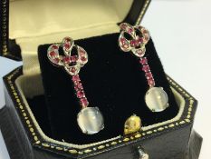 A pair of Ruby and Cats eye Moonstone pendant Earrings, contemporary design, set in silver.