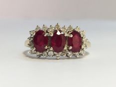 A Ruby and Diamond Trilogy Ring in 18ct yellow gold. The oval shape rubies have an ETCW of 0.