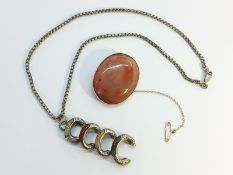 An Antique oval Scottish Agate brooch, in 9ct rose gold with safety chain attached.