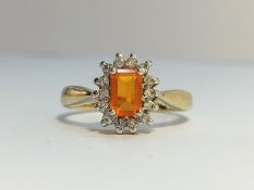 A Fire Opal and Diamond Cluster Ring set in 9ct yellow gold. The fire opal is estimated 0.