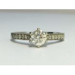 A Contemporary Solitaire Diamond Ring with Platinum Shank, with Diamond Set Shoulders.
