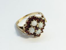 An Opal and Garnet Ring, hallmarked 9ct gold 1977, opals ETCW 0.80 ct. Ring size R, total weight 4.