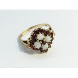 An Opal and Garnet Ring, hallmarked 9ct gold 1977, opals ETCW 0.80 ct. Ring size R, total weight 4.