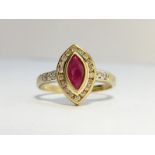 A Ruby and Diamond Ring in 9ct yellow gold. The marquise shape ruby has an ECW of 0.