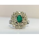 A 1970s Emerald and diamond cluster ring in 18ct white gold.