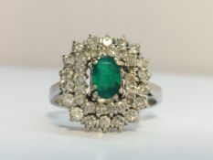 A 1970s Emerald and diamond cluster ring in 18ct white gold.