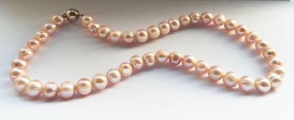 An 18” string of large Peach/Pink toned Cultured Pearls.