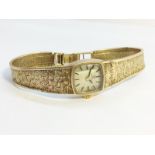 A Ladies 9ct Gold Omega Watch, textured strap. Working order, total weight 19.6 grams.