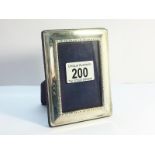 A Silver Photograph Frame, hallmarked 2000. Blue velvet back. Measuring approximately 11.