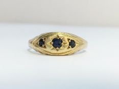 An Edwardian three stone sapphire ring set in 9ct gold. Ring size N, total weight 1.47 grams.