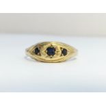 An Edwardian three stone sapphire ring set in 9ct gold. Ring size N, total weight 1.47 grams.