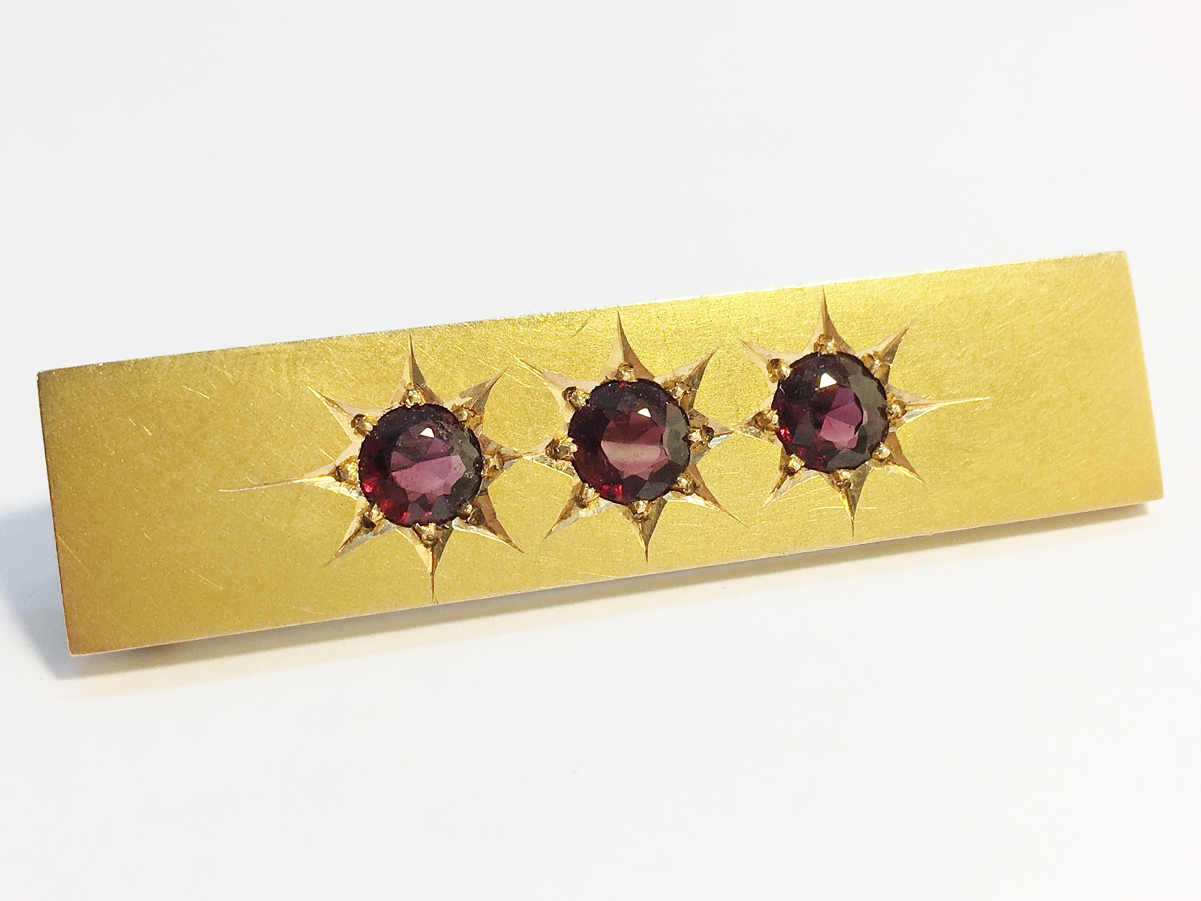 An Edwardian oblong garnet brooch set in 15 carat yellow gold.