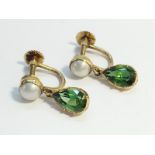 A pair of peridot and pearl drop earrings, circa 1970's. The pear shaped peridots have an ETCW of 3.