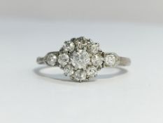 An Edwardian Diamond Cluster Ring with diamond set shoulders set in 18ct white gold with a platinum