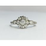 An Edwardian Diamond Cluster Ring with diamond set shoulders set in 18ct white gold with a platinum