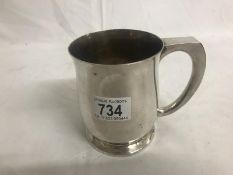 A 1890 silver crown set in bottom of a silver plated tankard.