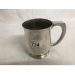 A 1890 silver crown set in bottom of a silver plated tankard.