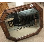 A Bushmills Irish whiskey advertising mirror in oak frame.