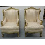 Matching Pair of carved giltwood Wingback Armchairs, peach and cream striped fabric, on cabriole