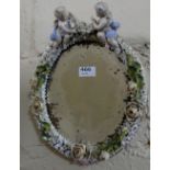 19thC Dresden Wall Mirror, the oval shaped insert mounted with applied flowers and two cherub