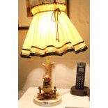 Hummell Table Lamp – figure of a girl seated on a fence, electric with a fluted shade, 16”h
