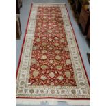 Red ground full pile woven bamboo silk runner, with an all over floral pattern, 3m x 1m