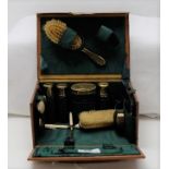 Leather cased miniature grooming set with brass bottles and brass lids, 8”w
