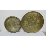 Two similar circular Indian brass wall plaques, each with figures on horseback, 18”dia & 22” dia