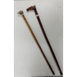 Two wooden walking sticks – 1 with carved handle in the form of a horse, with glass eyes & 1 with