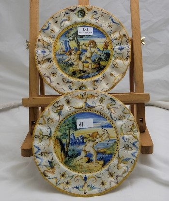 Pair of Fiance Ware Plates, with scalloped borders, cupids the foreground of lakes, each 10” dia