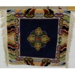 Woolwork wall hanging – a central medallion surrounded by various coloured borders, on a brass pole,