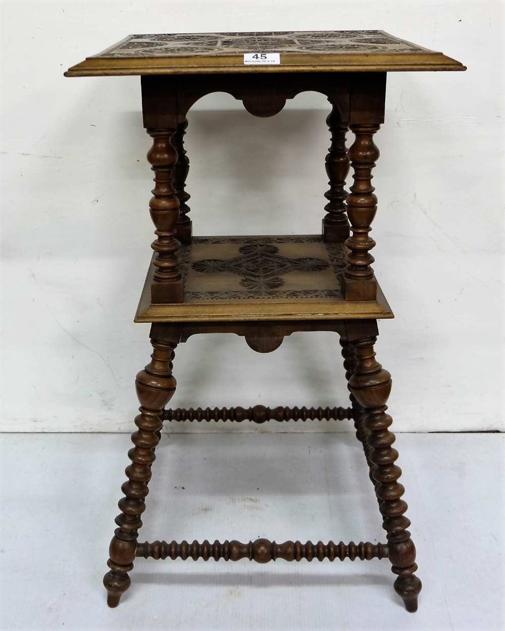 Walnut 2-tiered occasional table with a carved top and centre, bobbin twist legs and stretchers, 17"