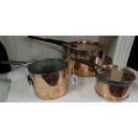 3 graduating antique copper saucepans, two with lids with handles, stamped