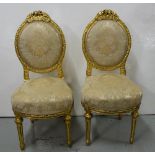 Matching Pair of carved Gilt Side Chairs, the oval backs mounted with foliate carvings, turned legs,