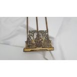 Late 19thC extending cast brass bookstand, the end plates featuring figures of man reading,