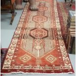 Rust ground Persian Hariz Runner, with a medallion design 4.05 m x 0.95 m