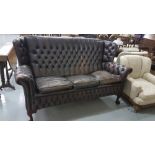 Mid 20th C brown leather covered settee, with buttoned in back, sides and front panel, leather worn,