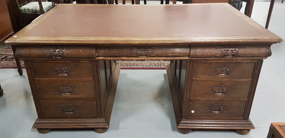 Carved oak kneehole partner's desk, with 3 apron drawers over 3 small drawers, with masked