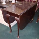 1960s drop leaf dining table with oval ends, pad feet, 39”d, extends to 53”