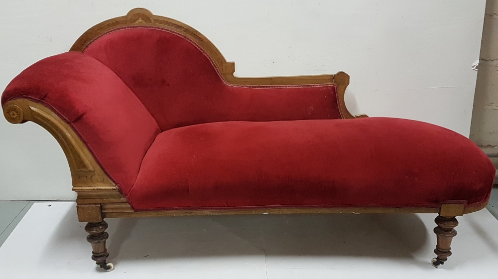Victorian walnut framed Chaise Longe, with an arched inlaid back and turned legs and castors, red