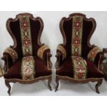 Pair of Victorian Mahogany Armchairs, with sabre legs and casters, with wool work and red velvet