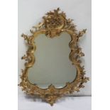 A late 19thC Carved Giltwood Mirror in the Rococo Taste, the pierced asymmetrical frame with