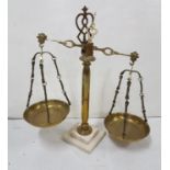 Brass shop counter weighing scales on a white marble base, brass pans, 21”h