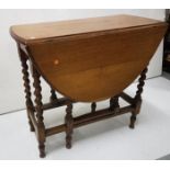 Oak drop leaf side table with oval ends on barley twist legs, 36”w, extends to 48”