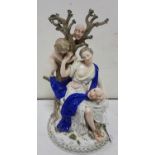 19thC Meissen Figure of a medieval woman with blue shawl, sitting by a tree with a cherub and 2